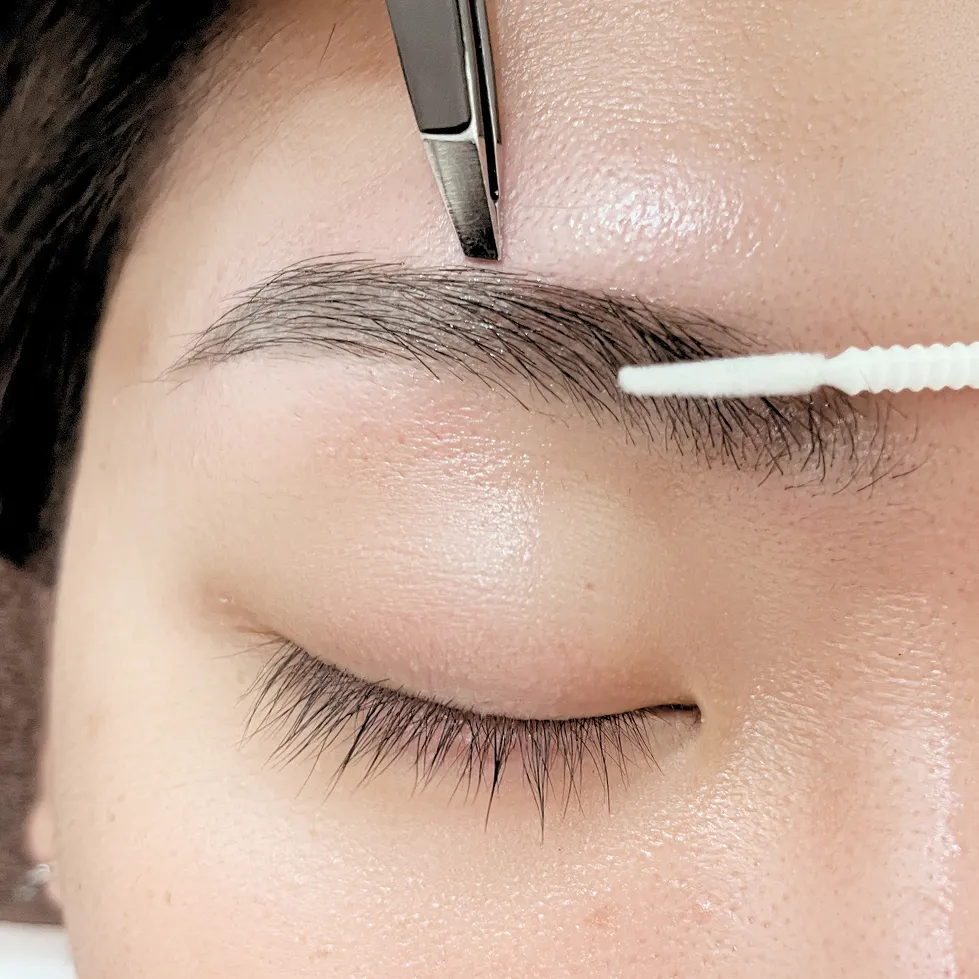 ブラシで眉毛を整える施術の様子
